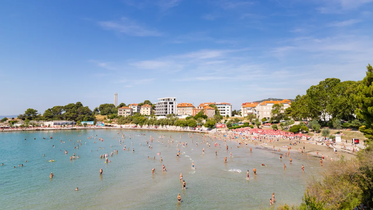 Aerial view of the sandy crescent of Bačvice bay in Split with the buildings behind it
