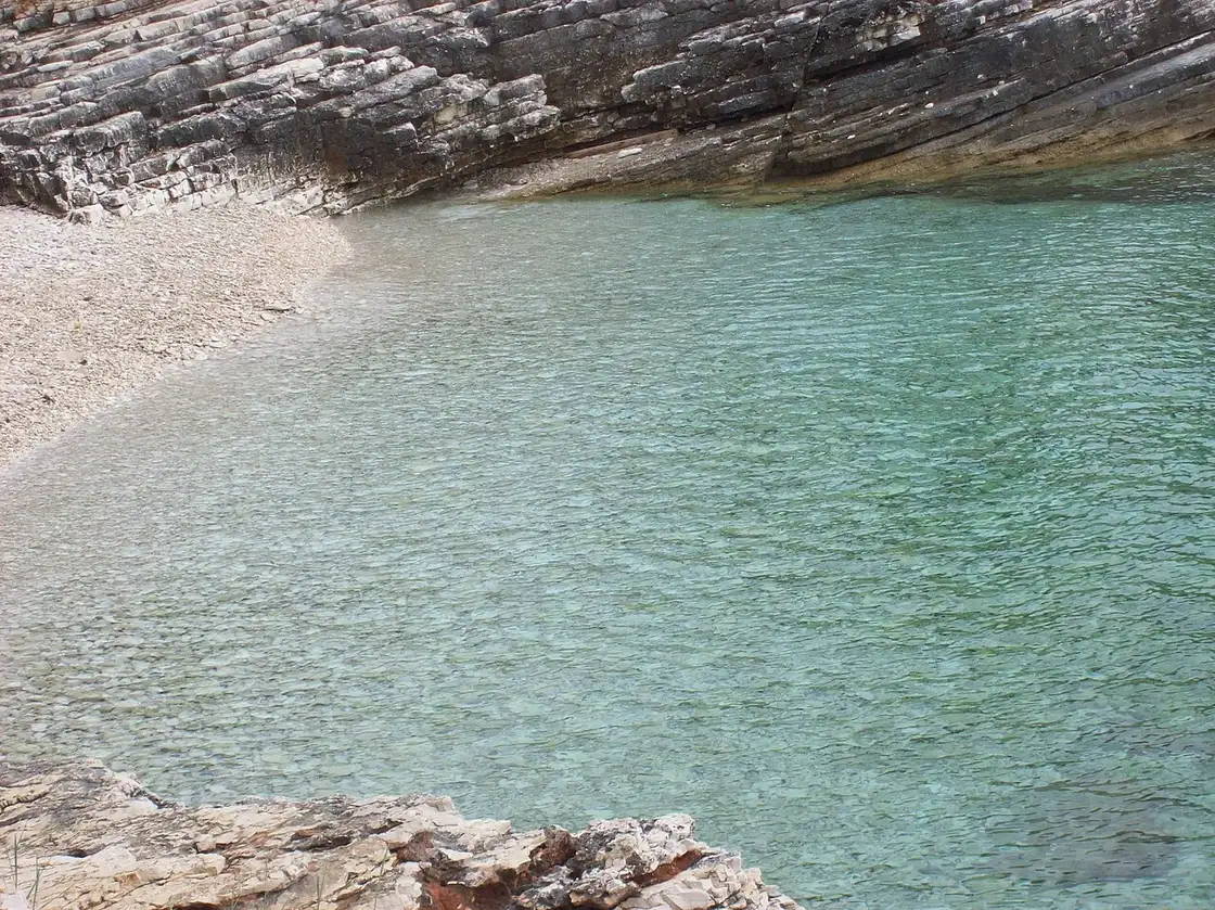 A quiet green cove with clear water on the Kamenjak peninsula in Istria in the shoulder season