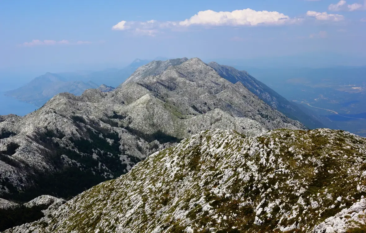 The bare grey karst ridges of the Biokovo massif rolling toward the distant Adriatic