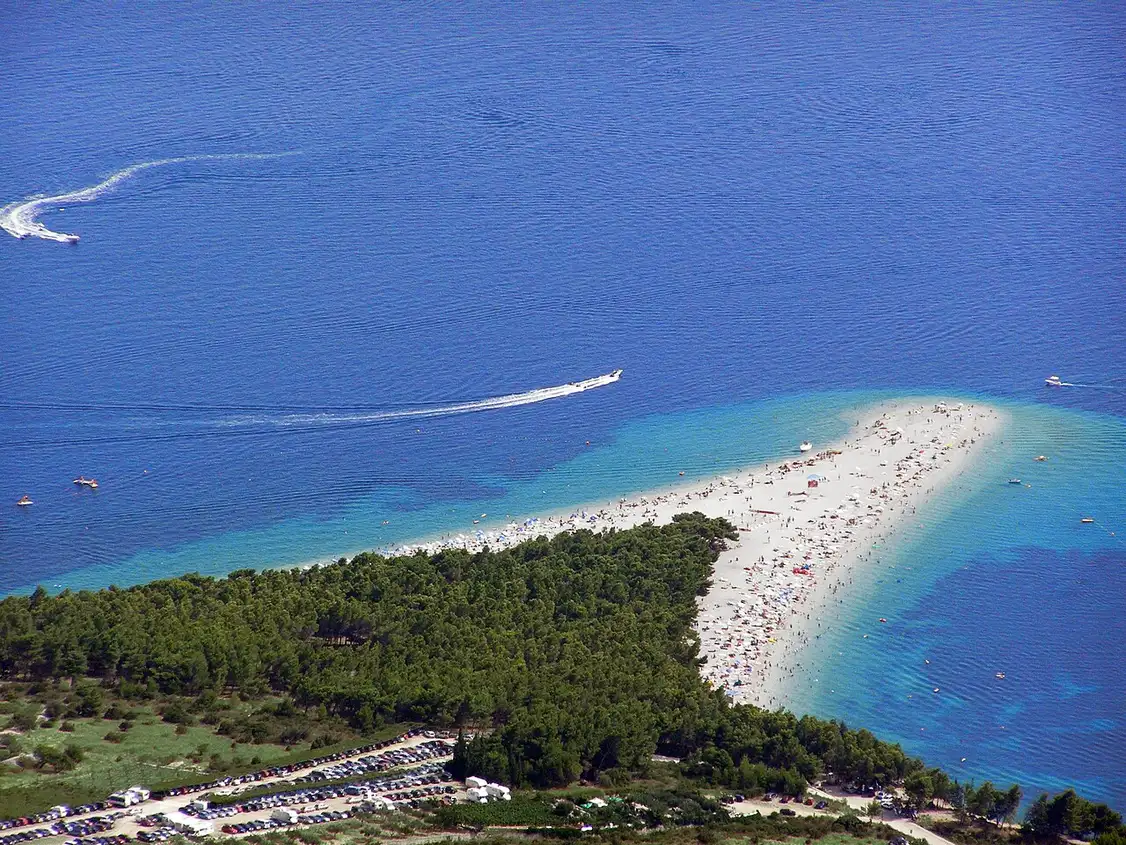 Zlatni Rat seen far below from the summit of Vidova Gora, a thin pale spit against the blue sea with Hvar beyond
