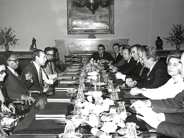 Black and white archive photograph of an official Yugoslav delegation meeting around a long table inside the White Villa on Brijuni in 1977