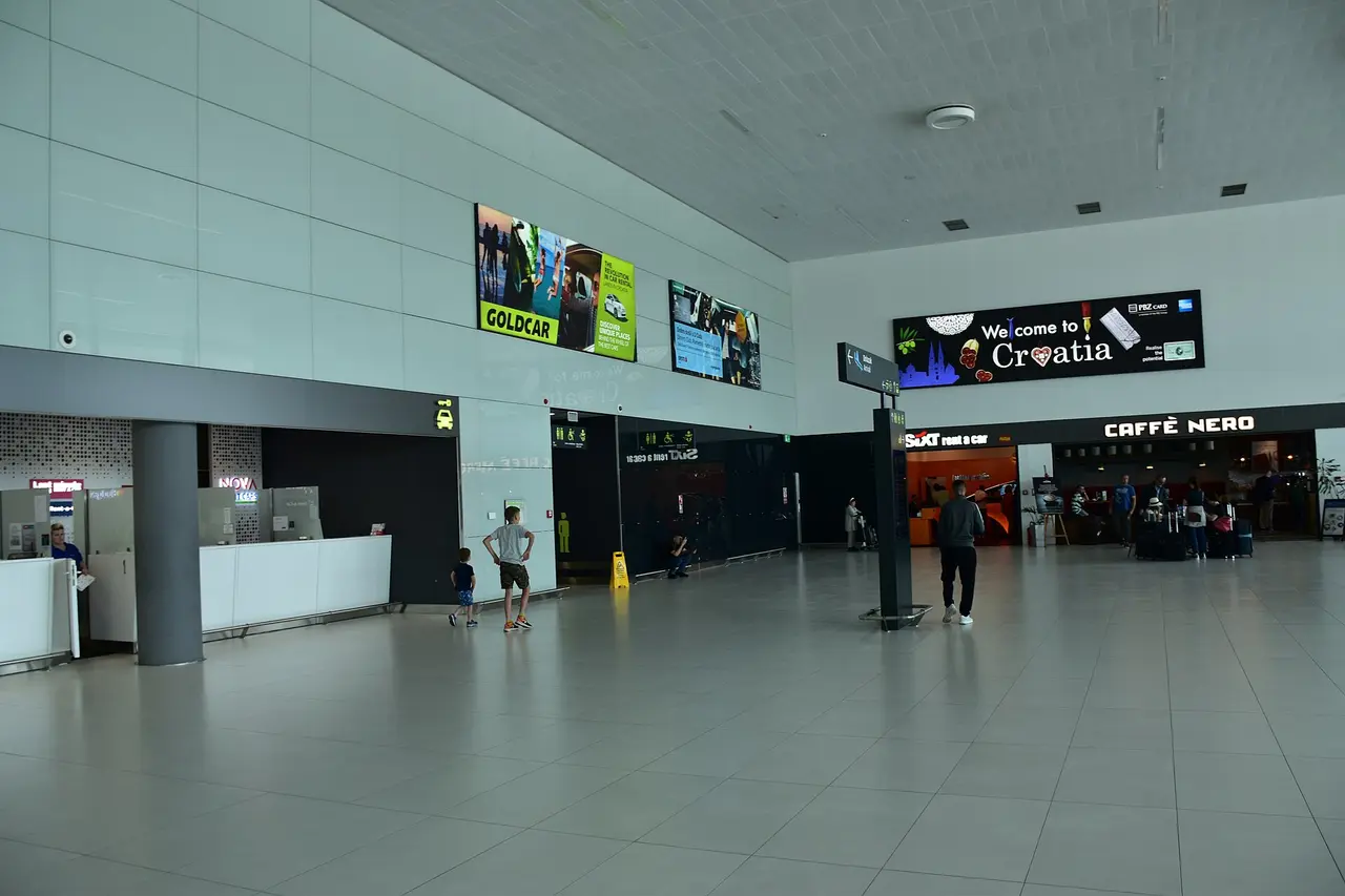 Zagreb Airport meet and greet hall with seating and passengers waiting near arrivals