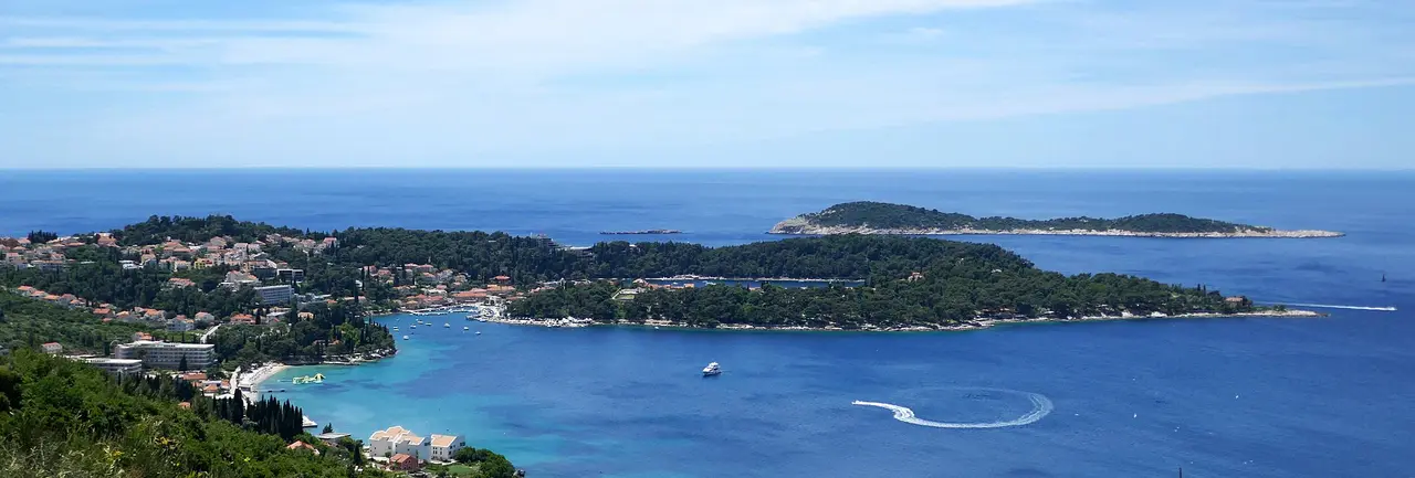 Wide panorama of Cavtat bay with the town along the shore and mountains inland