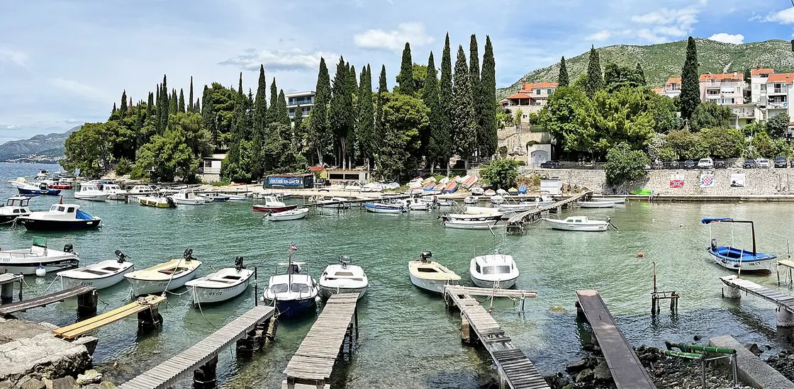 Cavtat harbour with boats, waterfront buildings and wooded hills across the bay