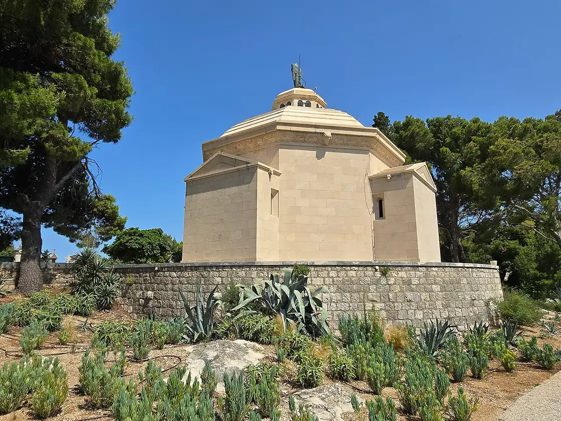 White stone Račić Mausoleum with cupola among cypresses above Cavtat