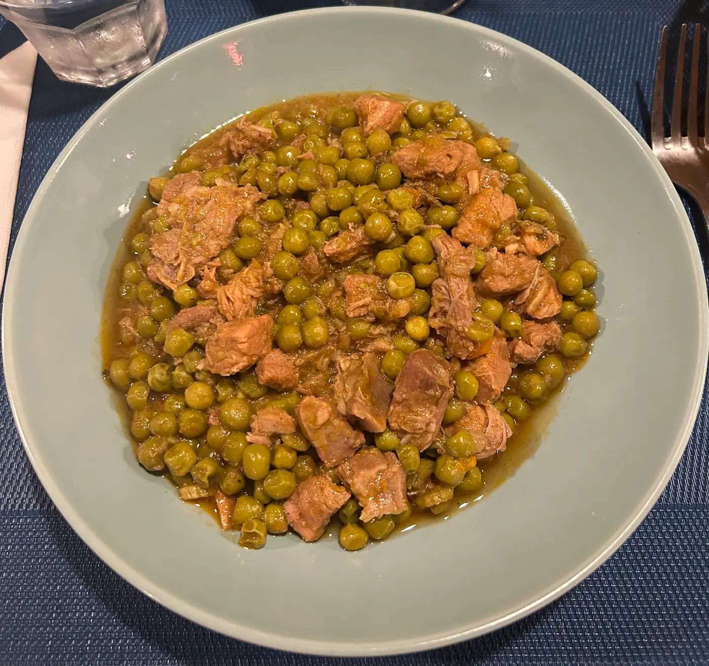 A plate of roast lamb served with peas, a classic Croatian meat dish