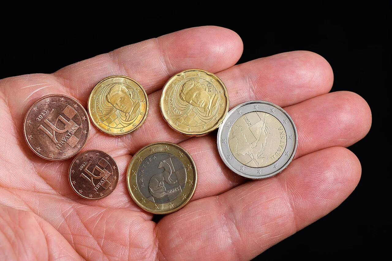 Croatian euro coins showing the national side, held against the Croatian flag