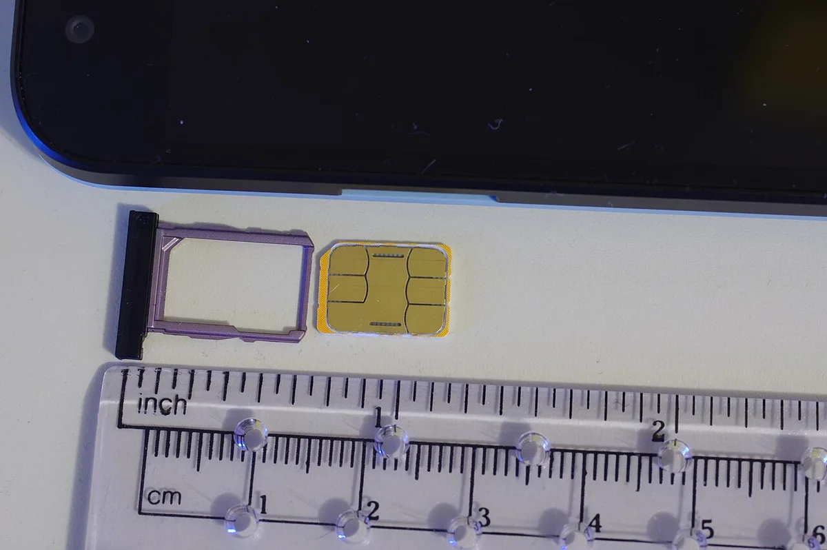 A nano SIM card sitting in a phone SIM tray ready to insert