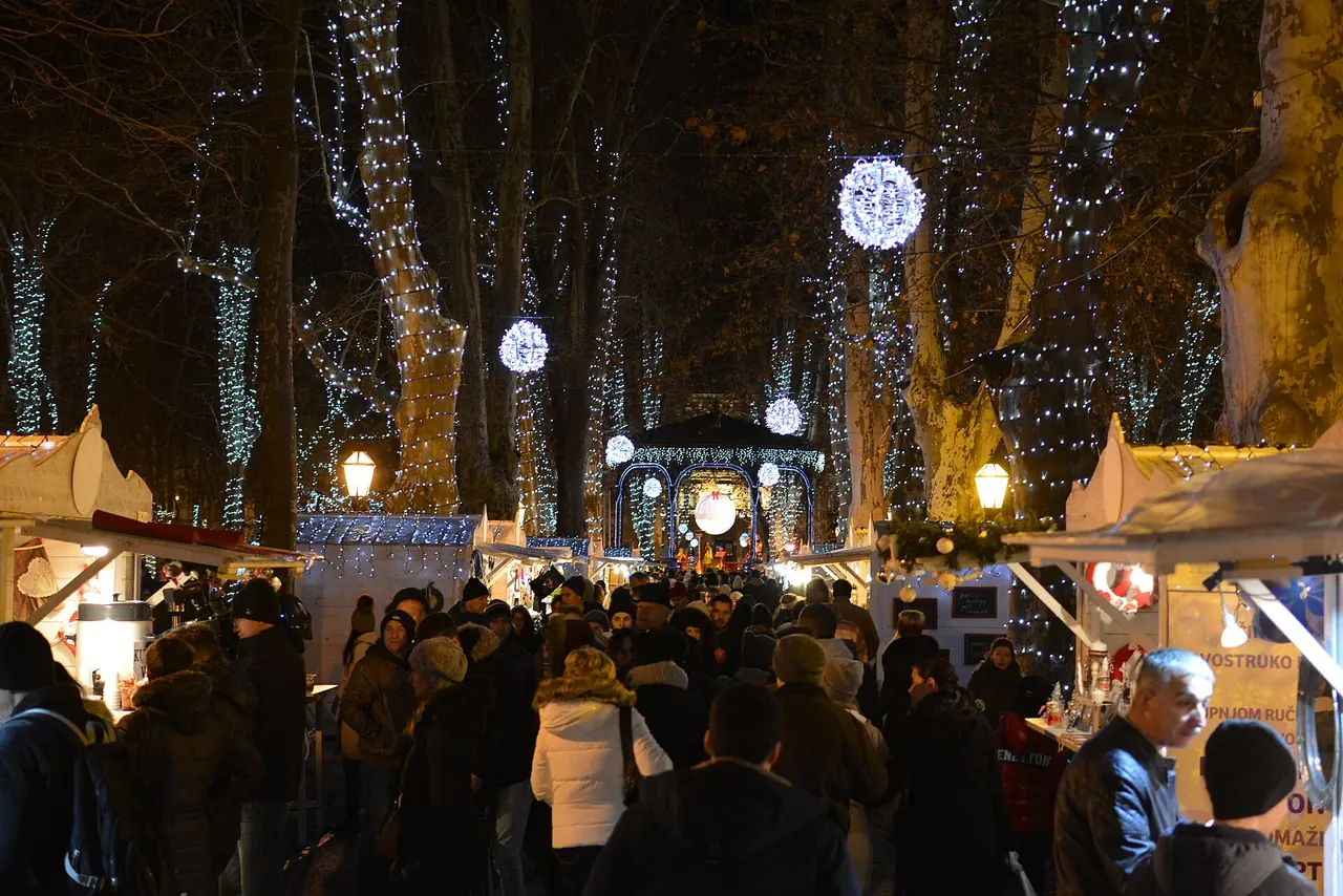 Advent market huts and illuminated trees in Zrinjevac park in Zagreb at night