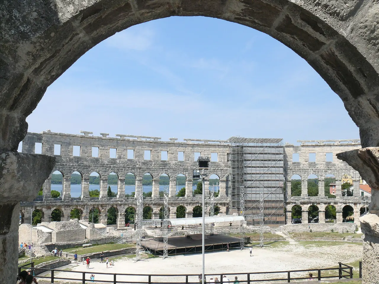 The interior of the Roman amphitheatre in Pula seen through an arch, with a stage built on the arena floor