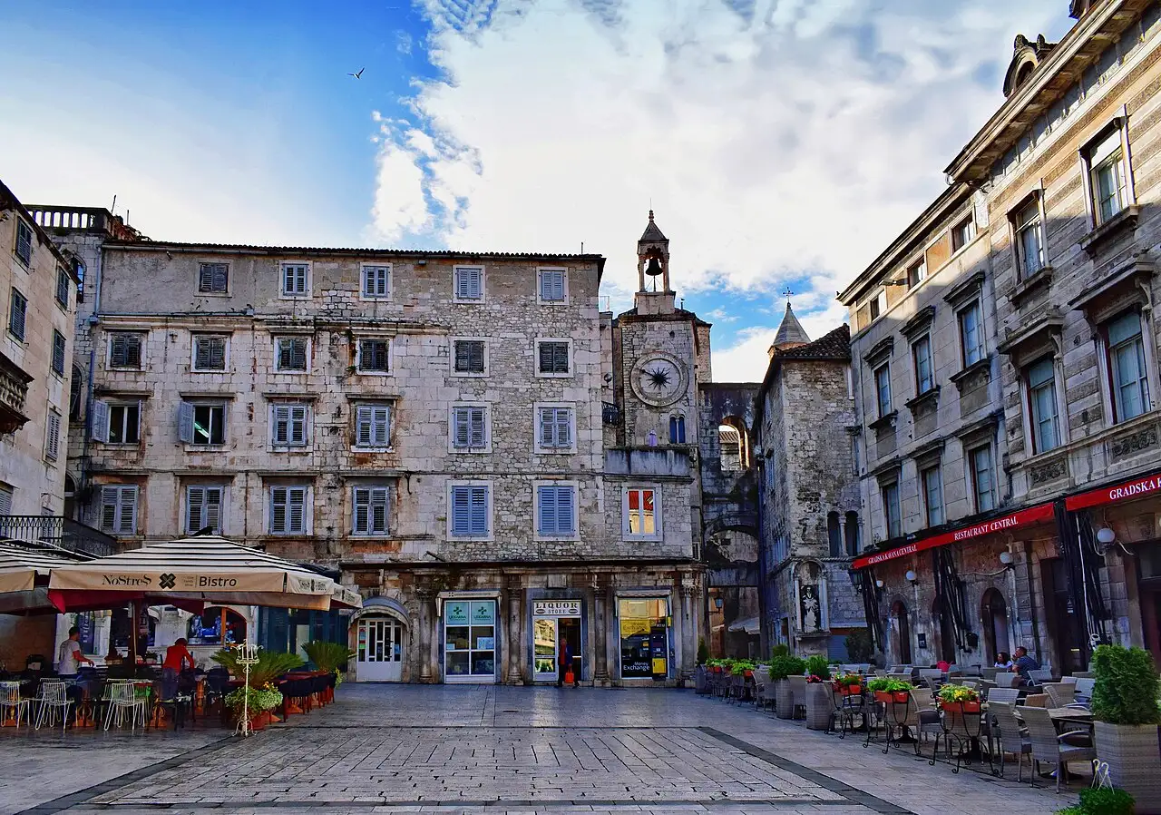 Diners at outdoor restaurant tables under parasols in the old town of Split