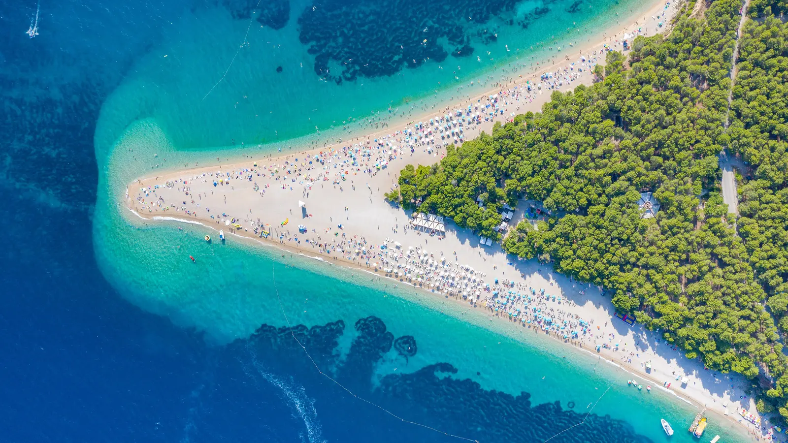 Aerial view of the Golden Horn (Zlatni rat) beach at Bol on Brač island, packed with summer bathers