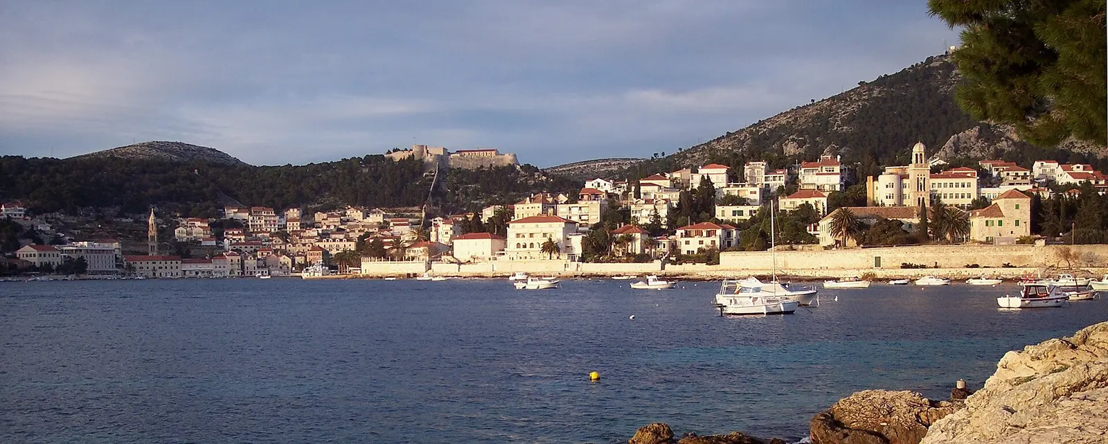 Panorama of Hvar town seen from across the water, with the Spanjola fortress on the hill above the harbour