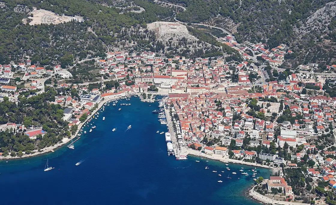 Aerial view of Hvar town and its harbour from the south, the fortress on the hill above