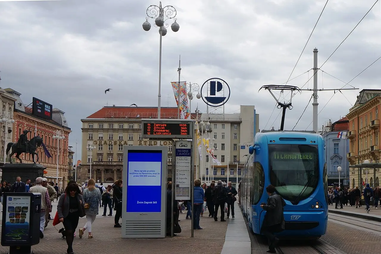 A blue tram crossing Ban Jelacic Square in central Zagreb with people walking