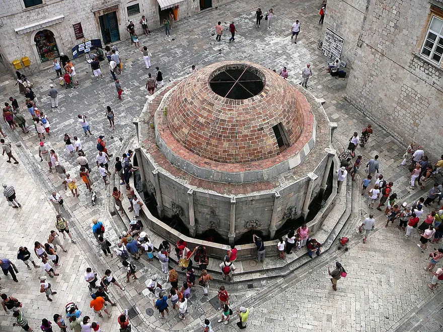 The large domed Onofrio Fountain in Dubrovnik old town with people around it
