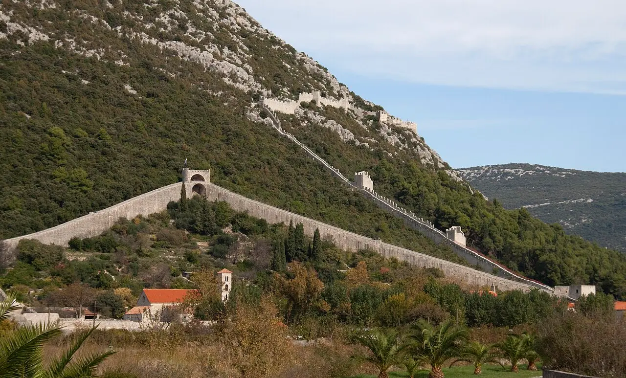 The medieval defensive walls of Ston climbing the hillside above the town