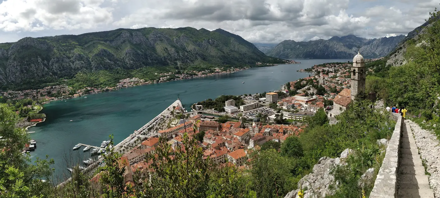 View from the town walls down over the red roofs of Kotor old town and the Bay of Kotor ringed by grey mountains
