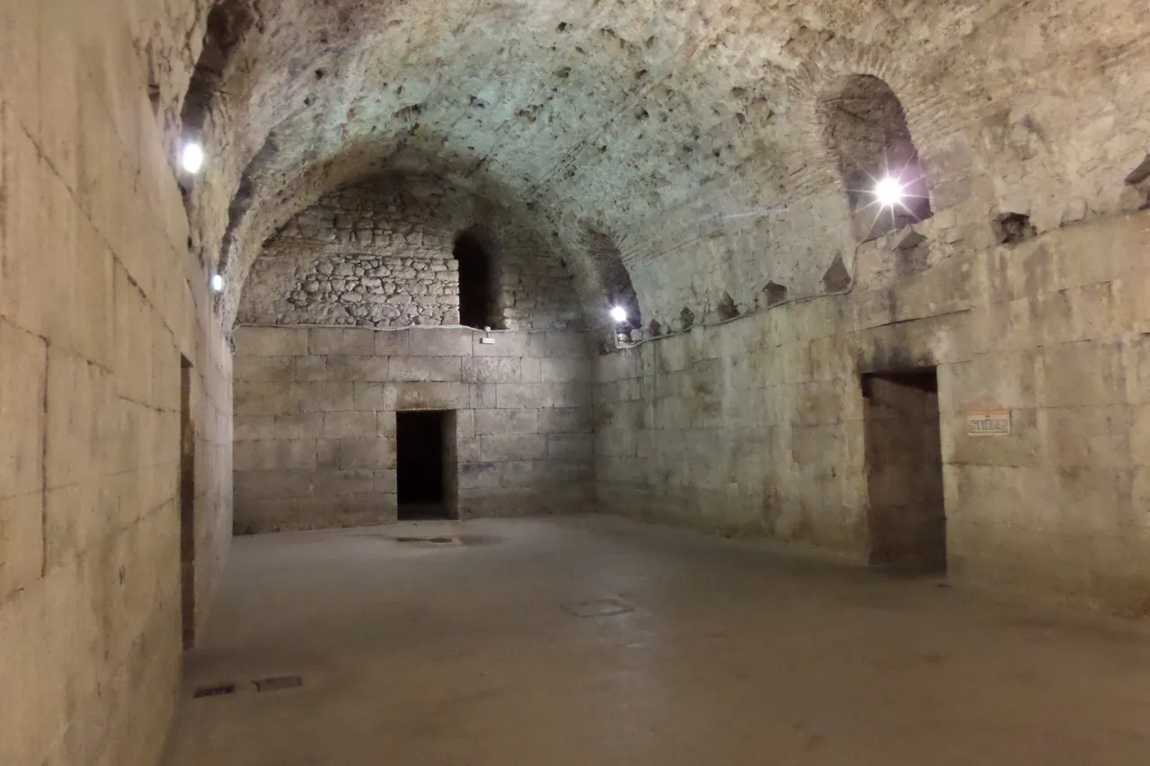 A large barrel-vaulted Roman stone hall in the cellars beneath Diocletian's Palace in Split, dimly lit bare stone