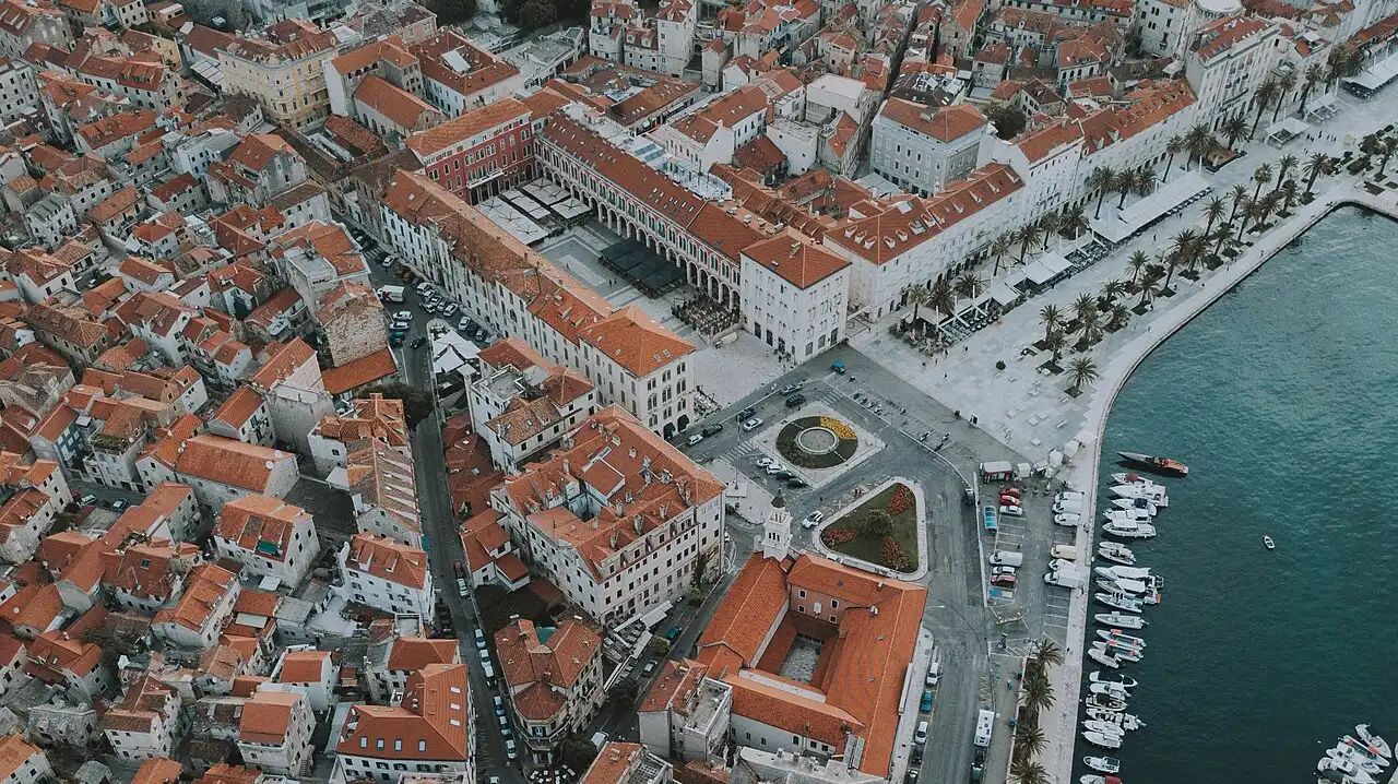 Aerial view of the old town of Split enclosed within the rectangular walls of Diocletian's Palace, with the cathedral bell tower rising above terracotta rooftops