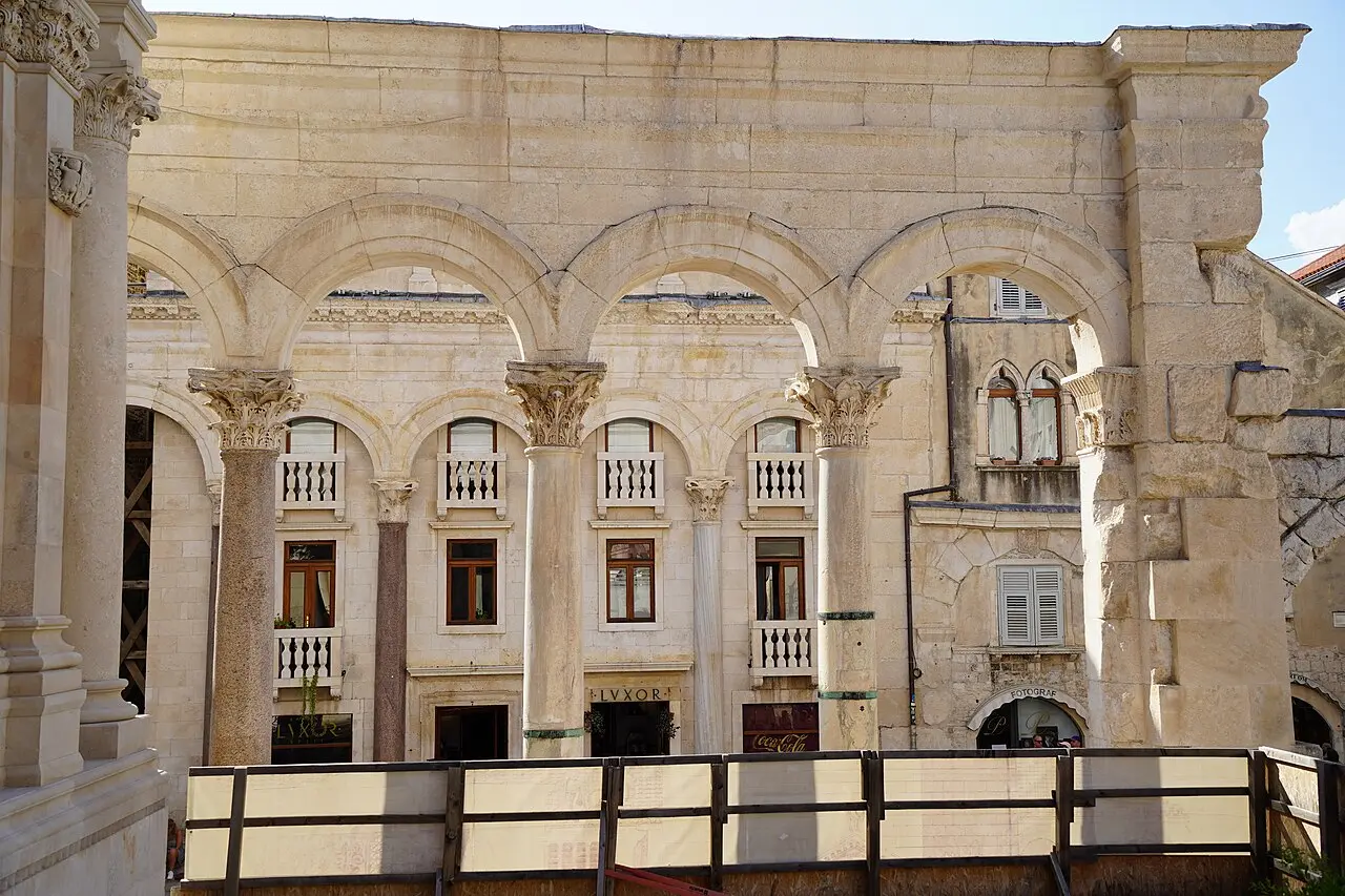 The massive stone walls and an arched gateway of Diocletian's Palace in Split viewed from a lane below
