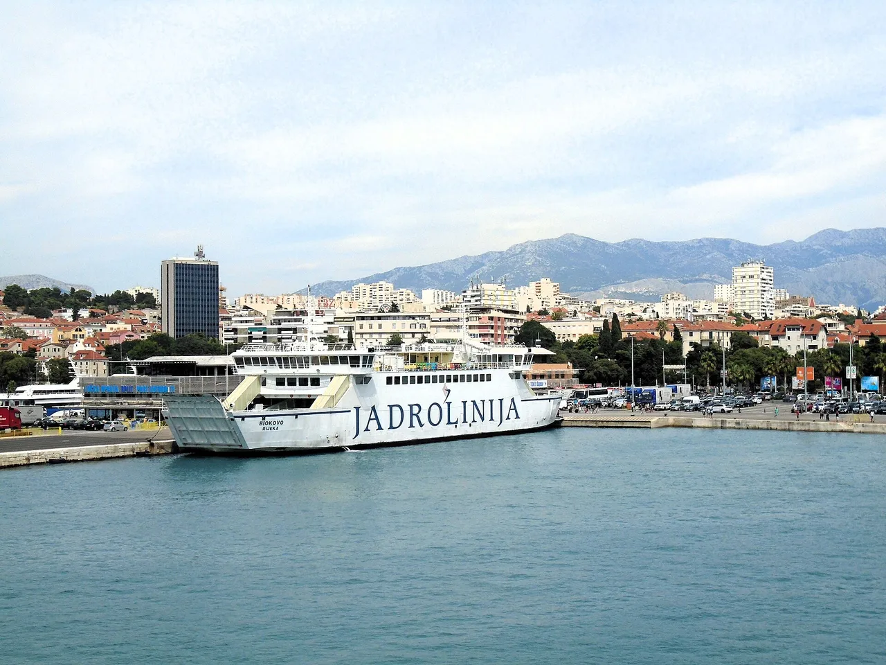 Ferries berthed at the Split ferry port with the city and hills behind