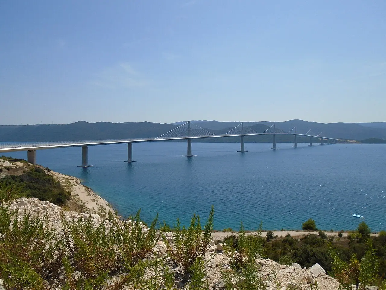 Pelješac Bridge seen from the north approach road over blue water