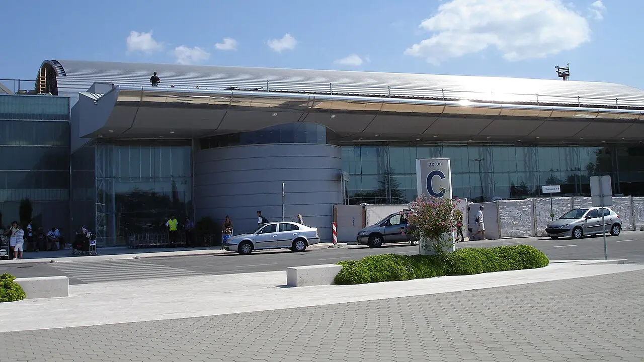 The terminal building at Dubrovnik Airport with cars parked outside