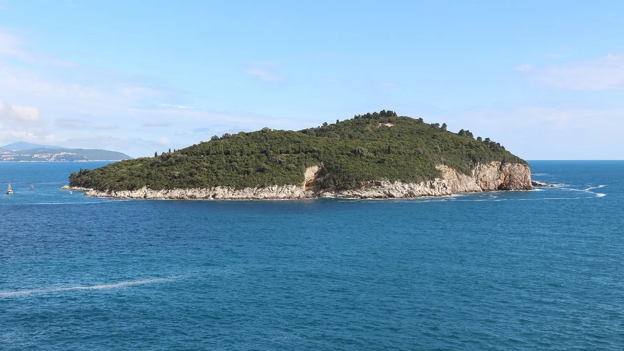 Lokrum island, a green wooded hump with pale limestone shore, in a calm blue sea