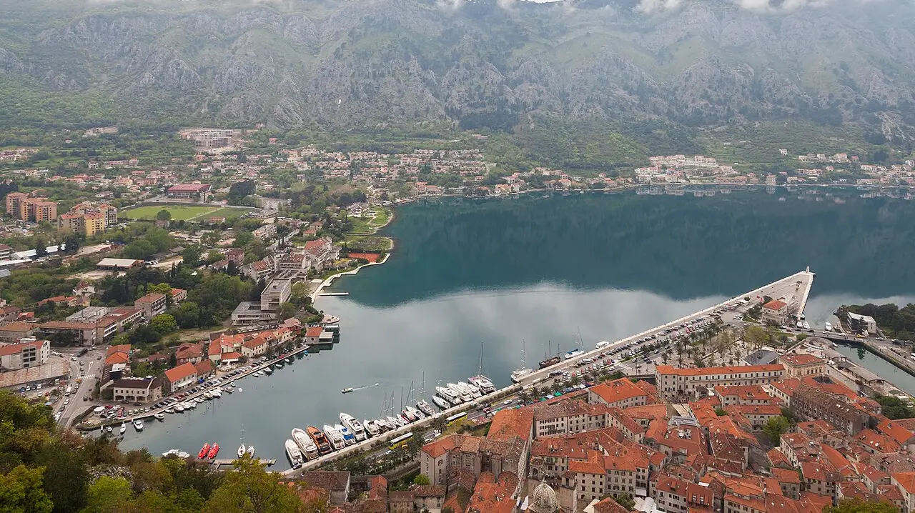 Aerial view of Kotor old town at the head of its bay, ringed by steep grey mountains