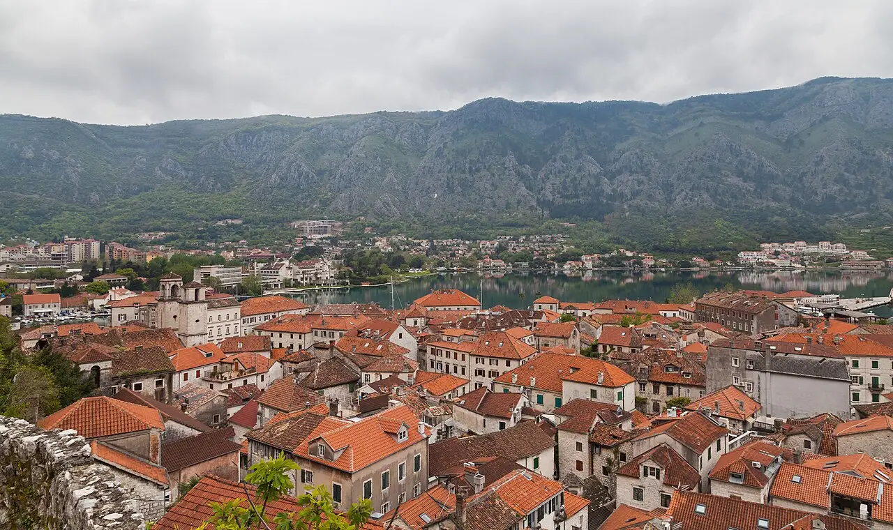 Terracotta rooftops of Kotor old town with the bay and mountains behind