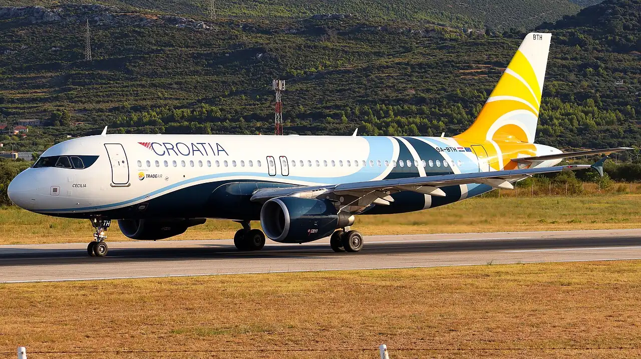 A Croatia Airlines Airbus A320 taxiing on the apron at Split Airport with the coastal hills behind