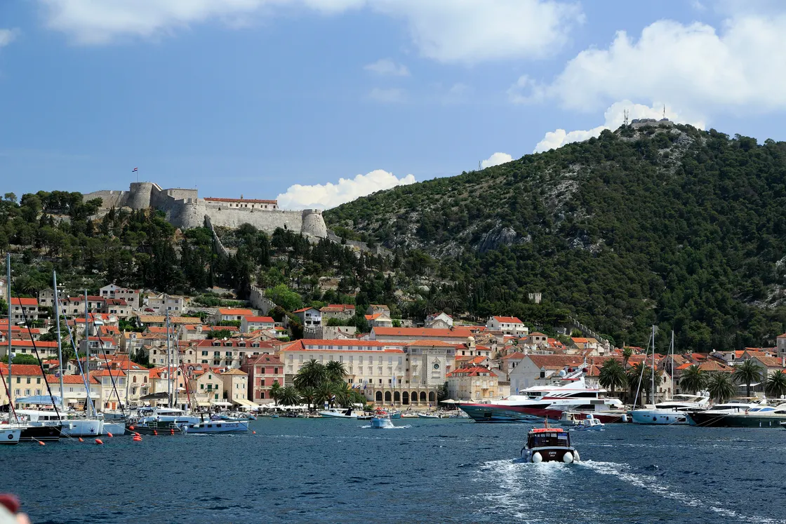 Hvar Town seen from the sea with the Španjola fortress on the hill above the roofs