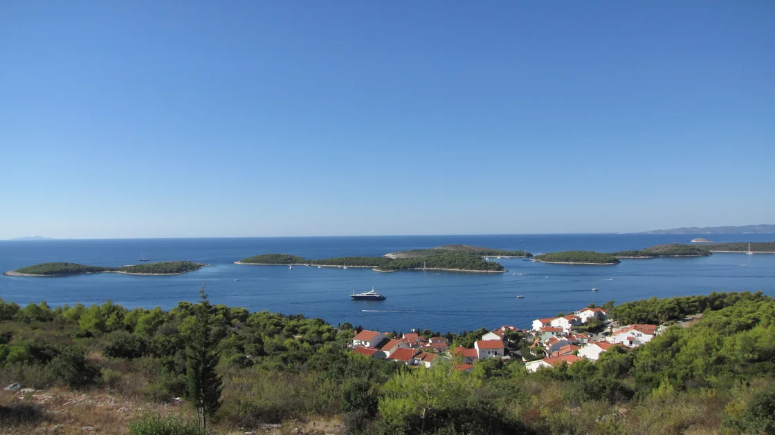 Wooded Pakleni Islands in a blue sea seen from the Hvar hillside under a clear sky