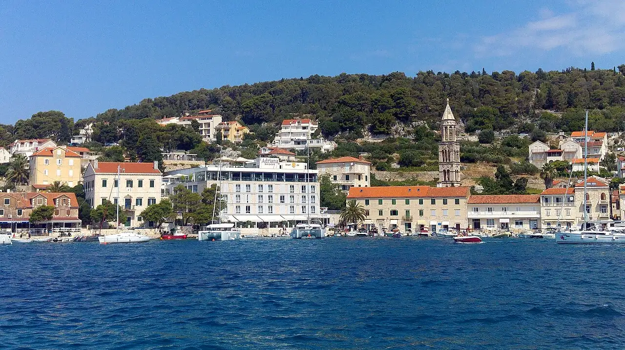 Hvar Town seen from the harbour — stone houses, the bell tower and boats on the Adriatic