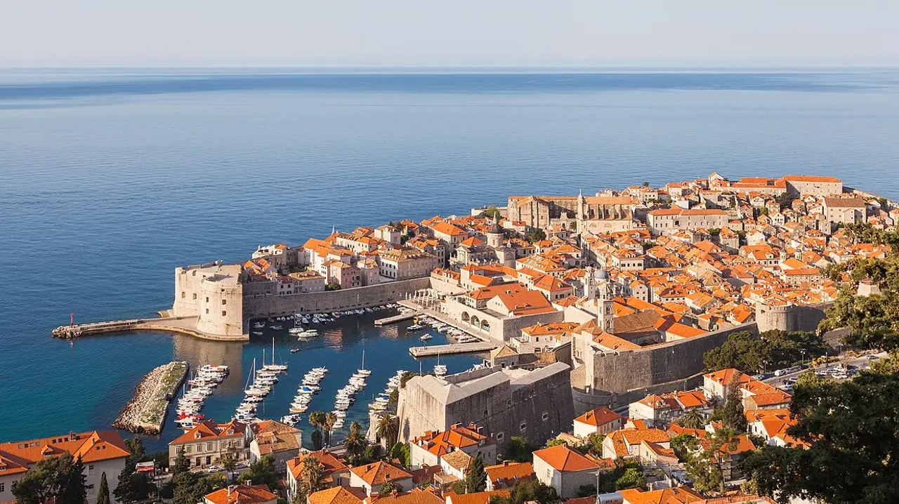 View over the terracotta roofs and city walls of Dubrovnik old town beside the blue Adriatic