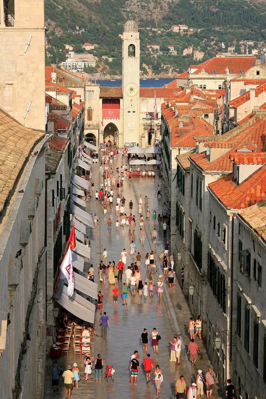 Crowds of tourists walking the polished limestone Stradun main street in Dubrovnik old town