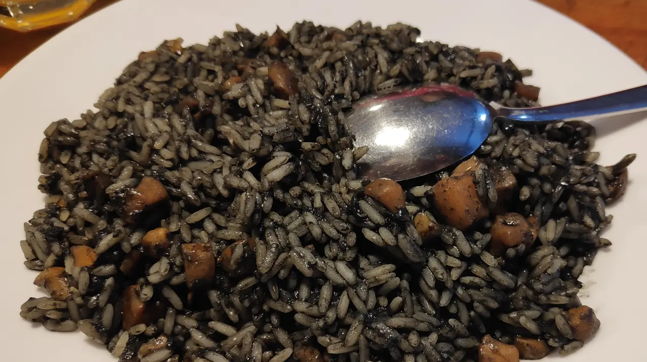 A plate of crni rižot — Dalmatian black cuttlefish risotto, a Split signature dish