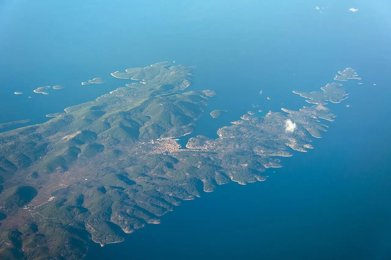 The town of Vela Luka wrapped around its deep bay at the western end of Korčula island, with boats and green hills