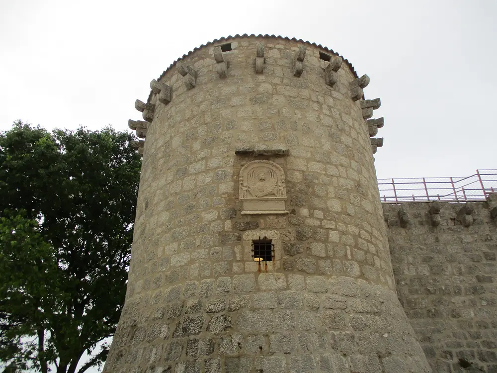The round corner tower of the Frankopan castle in Krk town with a stone coat of arms
