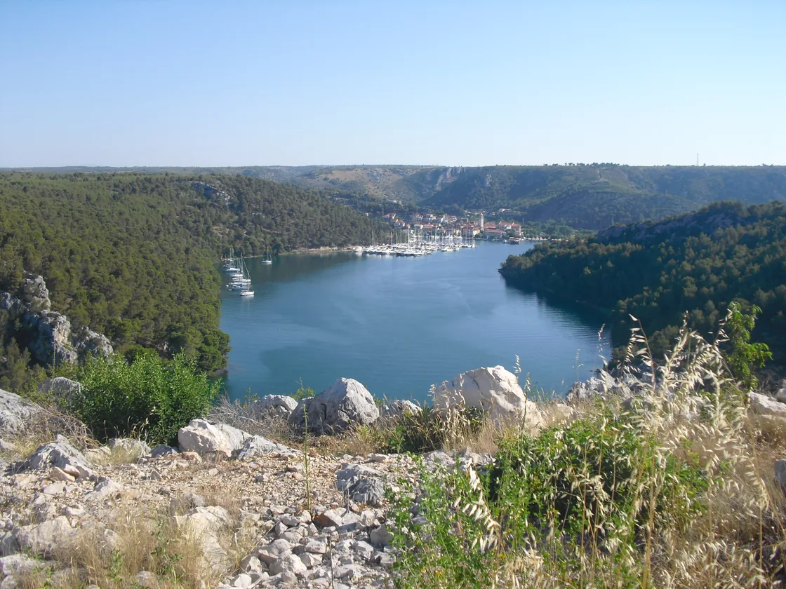 Yachts moored in the sheltered bay at Skradin below the wooded canyon walls