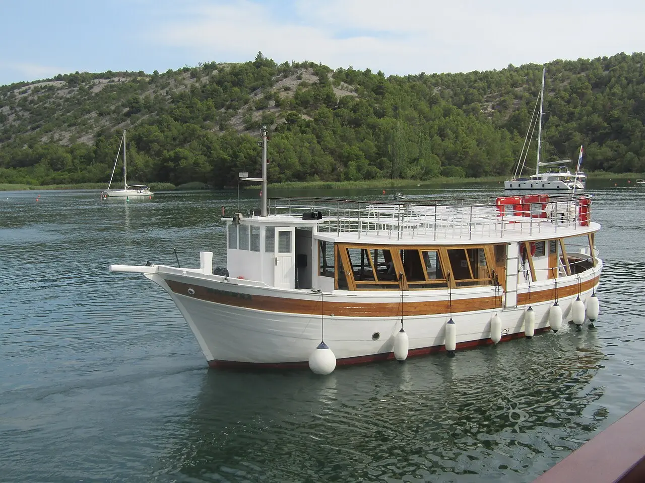 A wooden excursion boat moored on the Krka river