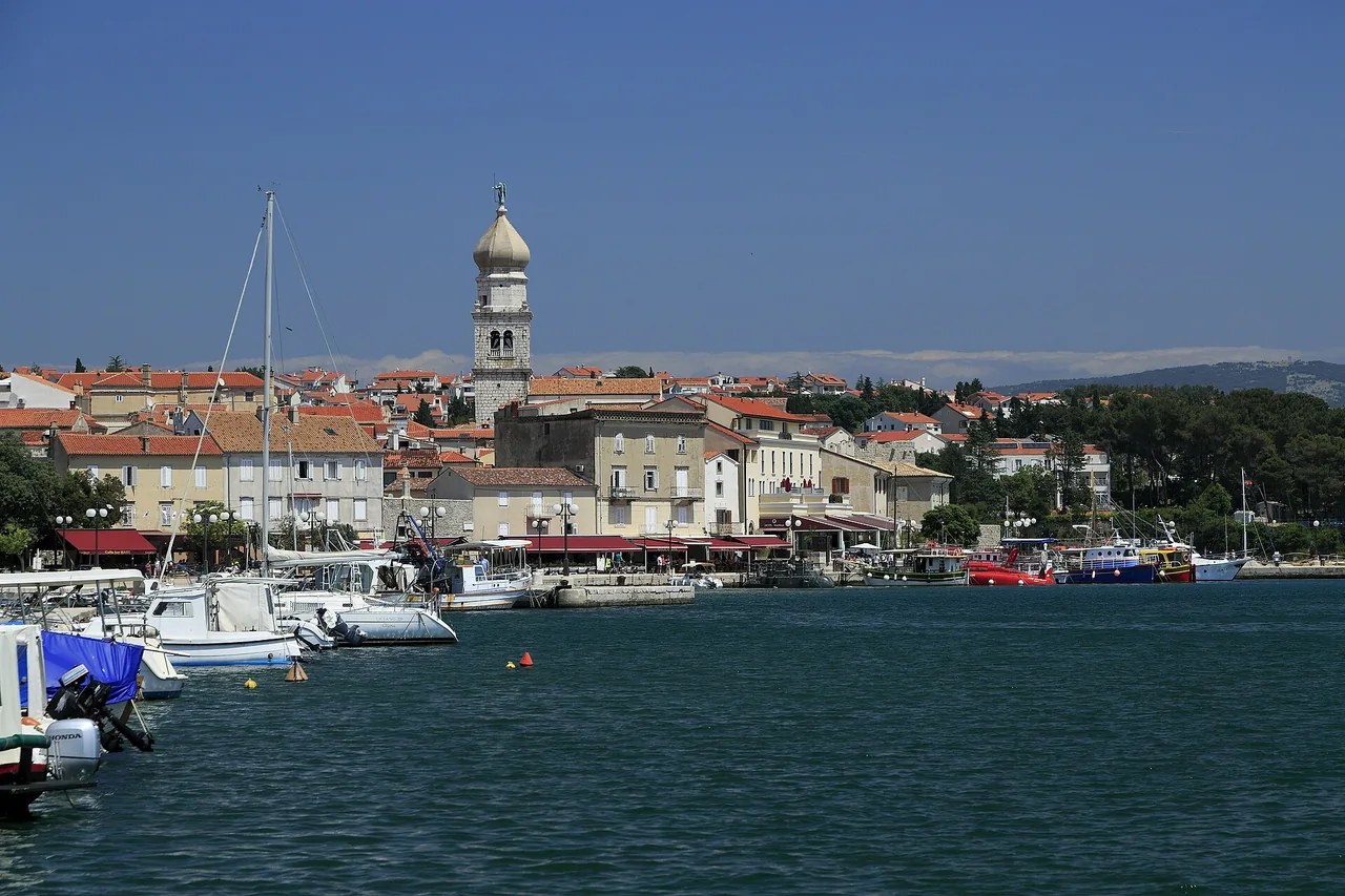 Stone houses and a harbourfront promenade in Krk town on a clear day