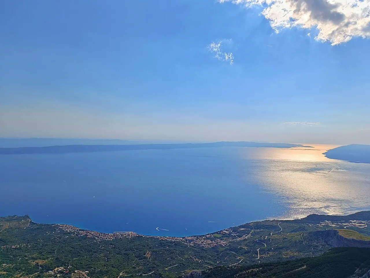 The Makarska Riviera coast and the Adriatic islands seen at sunset from high on the Biokovo road, with a town far below