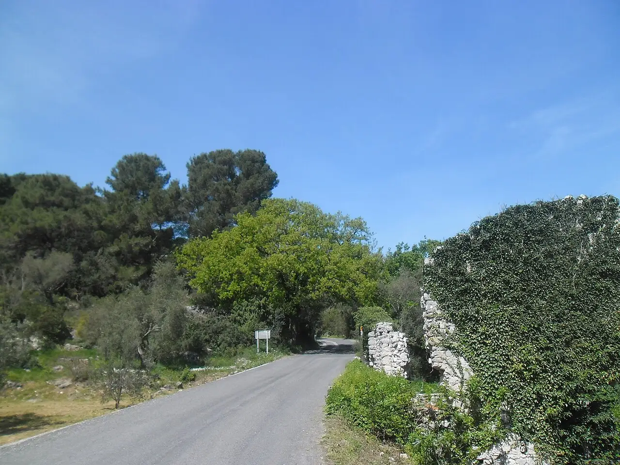 Stone houses and a lane in the village of Polače on Mljet, with the sheltered harbour behind