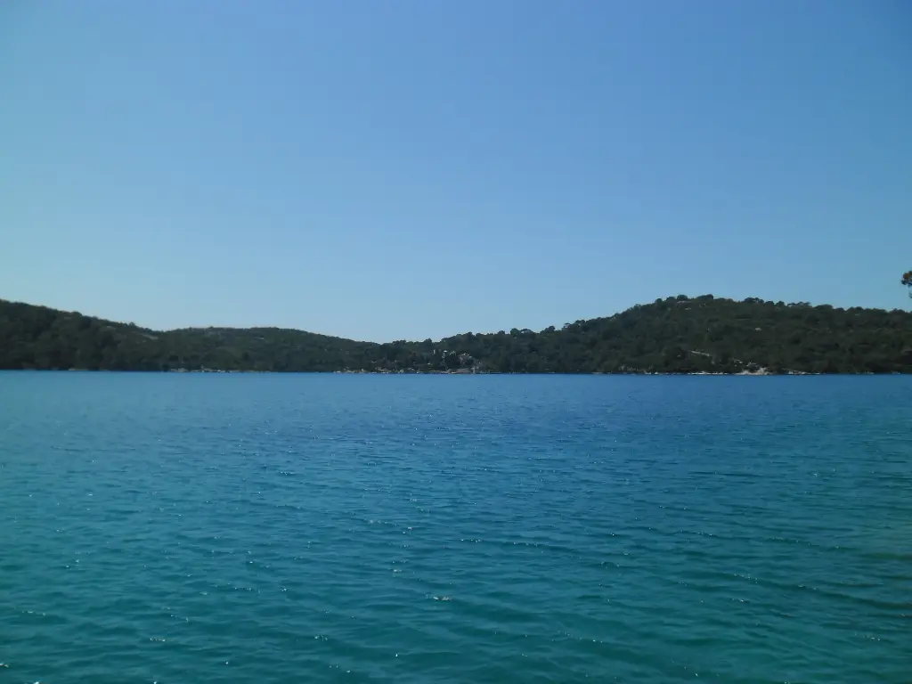 The still green water of Veliko Jezero in Mljet National Park, framed by dense pine forest