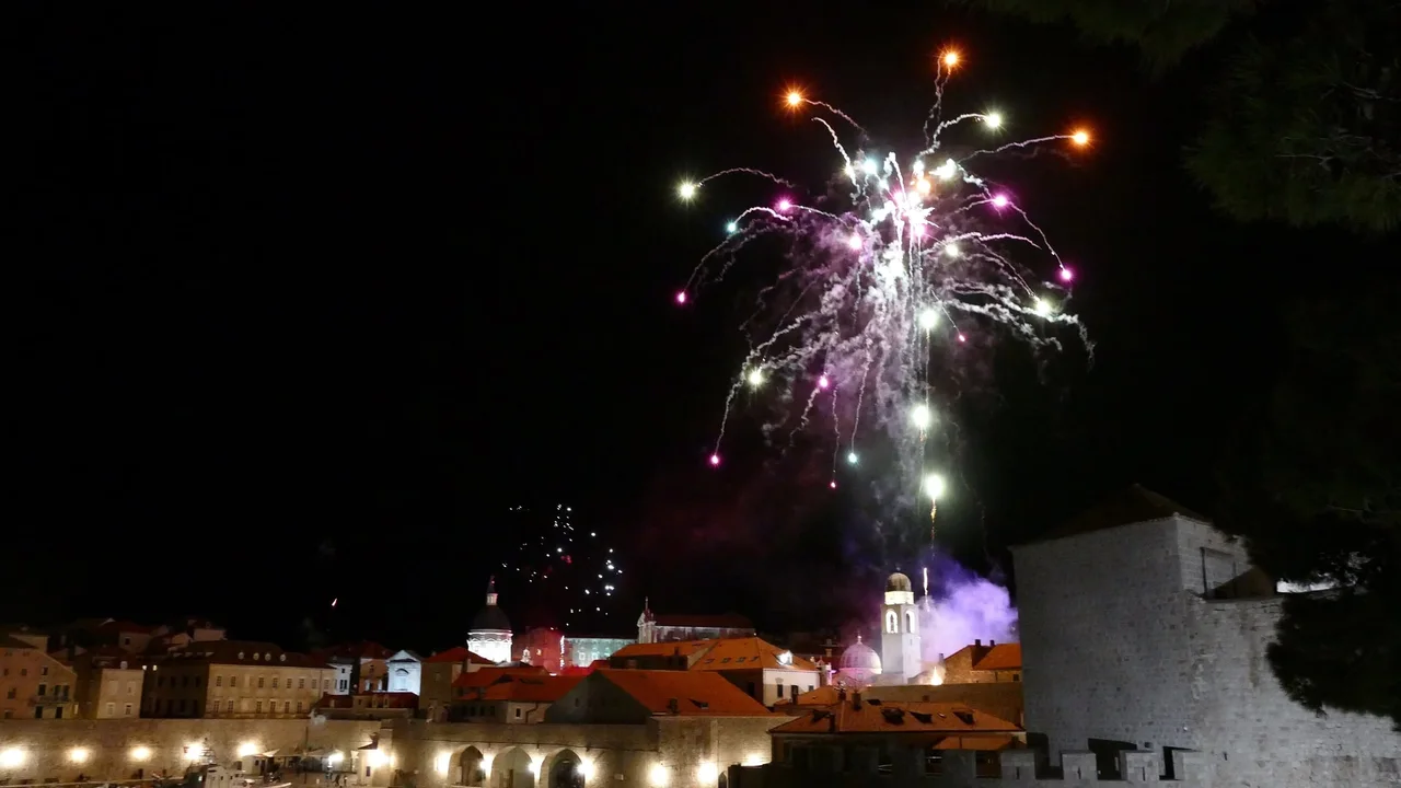 Fireworks over the rooftops and the old harbour wall of Dubrovnik at night