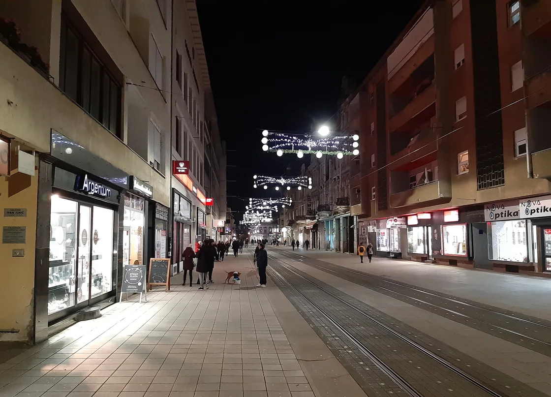 Kapucinska street in Osijek in the evening with festive lights over the street and tram tracks along it