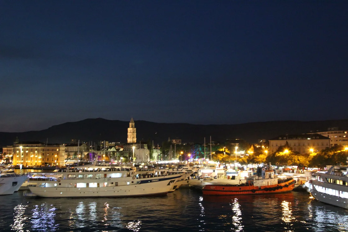 Split waterfront at night with the cathedral bell tower above the Riva and yachts moored along it