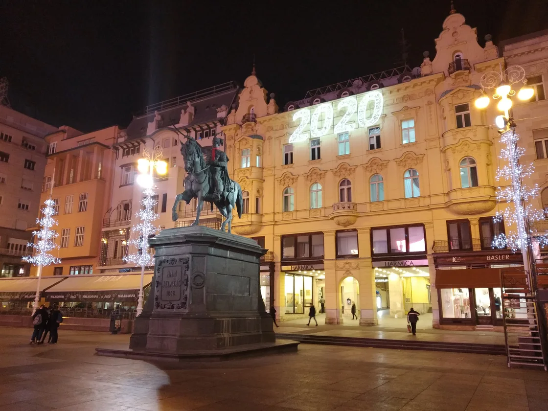 Ban Jelačić Square in Zagreb at night with the equestrian statue and the year numerals lit on a facade
